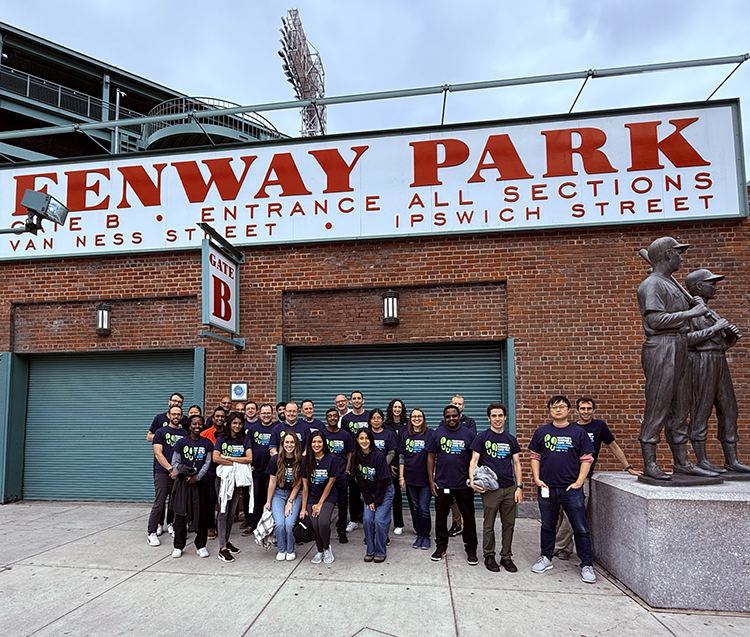 Group of people posing underneath Fenway Park sign.